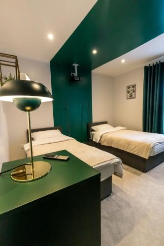 a bedroom with two beds and a table with a lamp at Checkered Wonderland at 19 Milbanke in Doncaster