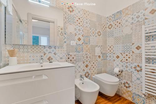 Fiordarancio Room Rental في مونتيروسّو ال ماري: حمام مع مرحاض بالوعة ومرآة