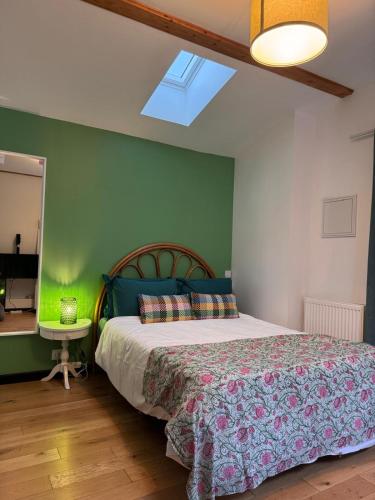 a bedroom with a bed and a green wall at GREEN&PURPLE STUDIO 24-24 Access in Bois-Colombes