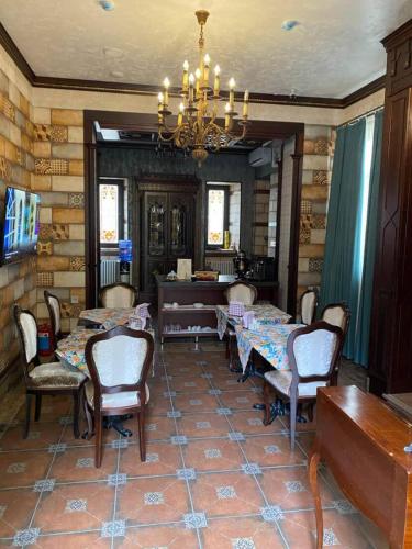 Un comedor con mesas y sillas y una lámpara de araña. en Historical Old City Hotel, en Baku