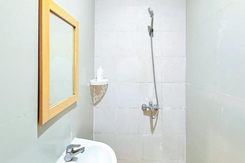 a bathroom with a shower and a sink and a mirror at Sans Stay Wonder Karapitan in Bandung