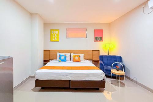 a bedroom with a bed and a blue chair at Sans Stay Wonder Karapitan in Bandung