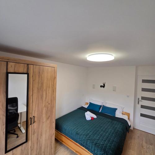 Słoneczny Apartament Panorama 5 7 z Widokiem na Jezioro i Góry في بولانكسيك: غرفة نوم بسرير اخضر ومرآة