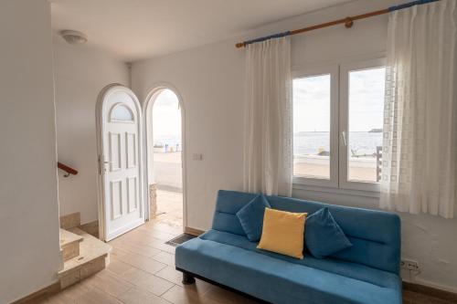 a blue couch in a living room with a view of the beach at Casa Abril by Escape Home in S'Algar