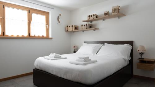 a bedroom with a large white bed with towels on it at Zardin 7 in Valdidentro