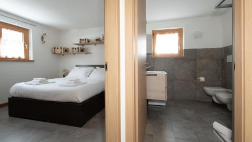 a bedroom with a bed and a bathroom with a toilet at Zardin 7 in Valdidentro