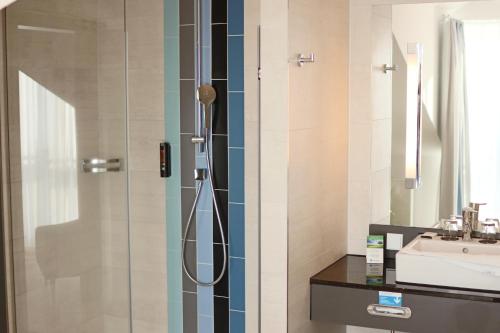 un baño con ducha y lavabo en Hafenhotel Meereszeiten, en Heiligenhafen