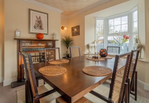 a dining room with a wooden table and chairs at YR HEN FICERDY in Aberystwyth