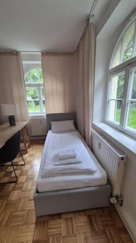 Bavaria Home Studio with terrace في غايزنفلد: غرفة نوم بها سرير في غرفة بها نوافذ