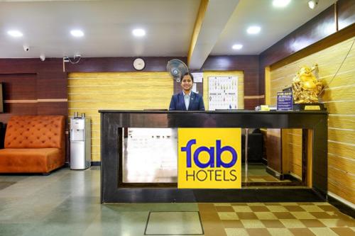 un hombre parado detrás de una recepción en el vestíbulo de un hotel en FabHotel Ocean View Apartment - Nr Dabolim Airport, en Old Goa