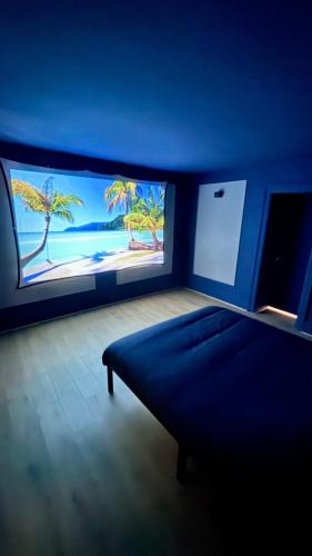 una camera blu con un letto e un grande schermo di Cosy 4 - Belfort centre a Belfort