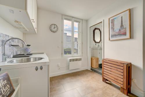 a kitchen with a sink and a window at Le Charme Parisien - 15 min des Champs-Elysées in Saint-Ouen