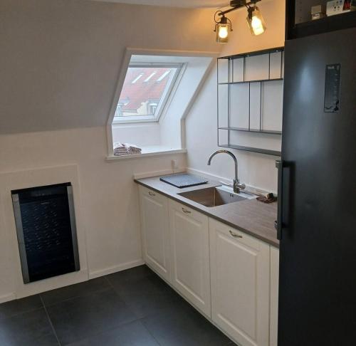 a small kitchen with a sink and a window at Eksklusiv stort boende i Fredrikshavn in Frederikshavn