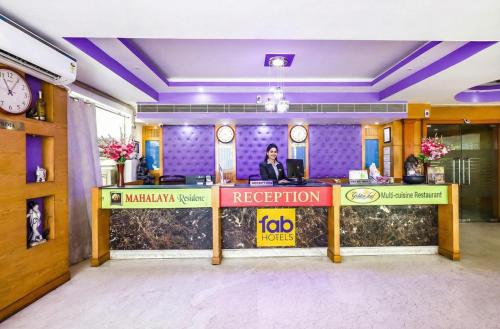 a reception desk in a hotel lobby with a person at Fabhotel Prime Mahalaya Residency - Nr Pallavaram Railway Station in Chennai