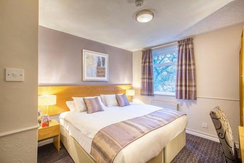 a bedroom with a large bed and a window at The George Inn in Selby