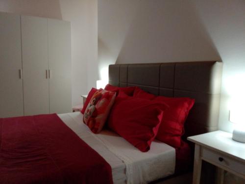 ein Schlafzimmer mit einem Bett mit roten Kissen darauf in der Unterkunft B&B L'incanto del Golfo in Agropoli