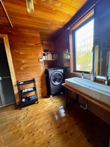 a bathroom with a sink and a washing machine at ゲストハウス カタツムリ in Shiogama