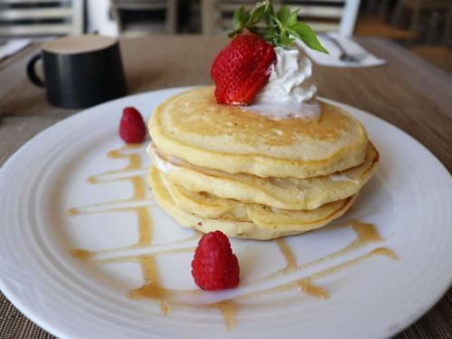 a stack of pancakes with strawberries on a plate at Novotel Monterrey Valle in Monterrey