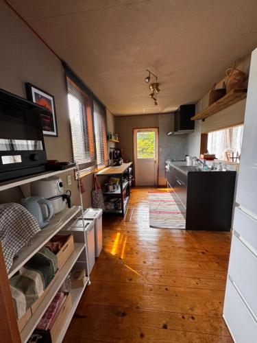 a kitchen with wooden floors and a kitchen with a sink at カタツムリ in Shiogama