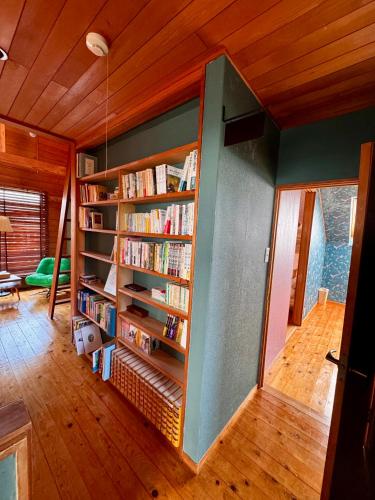 a room with a book shelf filled with books at カタツムリ in Shiogama