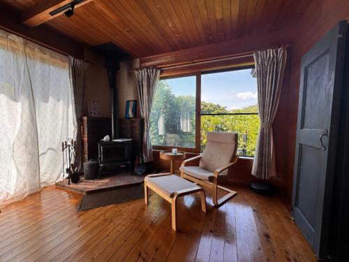 a living room with a chair and a window at カタツムリ in Shiogama