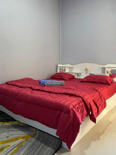 a bed with a red blanket and red pillows at Kubu home stay in Ban Ko Sawat