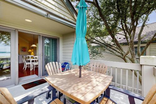 un tavolo con un ombrellone blu su un portico di Pelican Watch 1350 a Seabrook Island