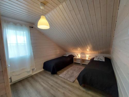 due letti in una piccola stanza con una finestra di Sunski a Syöte