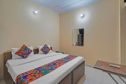 FabHotel Hare Rama في Prayagraj: غرفة نوم بها سرير وطاولة