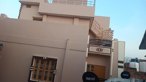 ein weißes Gebäude mit 2 Fenstern und einem Balkon in der Unterkunft Shri Ram Bhavan Homestay in Varanasi