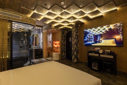 a room with a shower and a bed and a television at Pynt Hotel 7 in Ho Chi Minh City