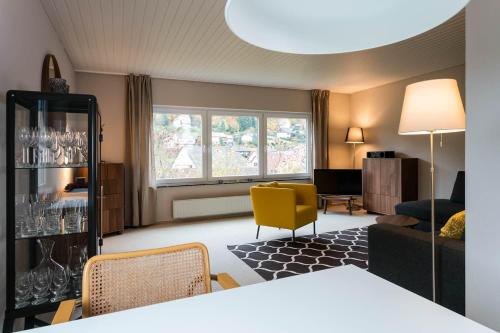 a living room with a couch and a yellow chair at Haus am Sagenweg in Nothweiler