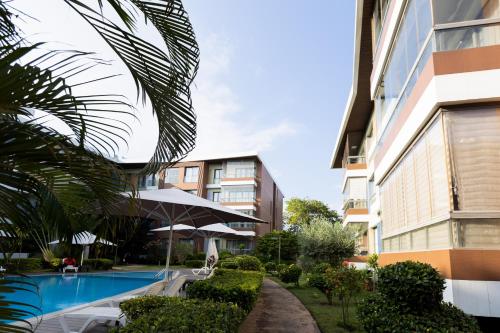 a hotel with a swimming pool next to a building at The Pearl In City by WOW Property - Direct from developer in Accra