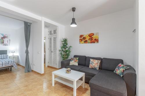 un soggiorno con un divano e un tavolo di Vv Caracola a Puerto de Mogán