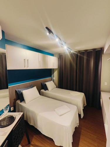 a hotel room with two beds and a table at Flat Expo Anhembi WiseSP Accommodations in São Paulo
