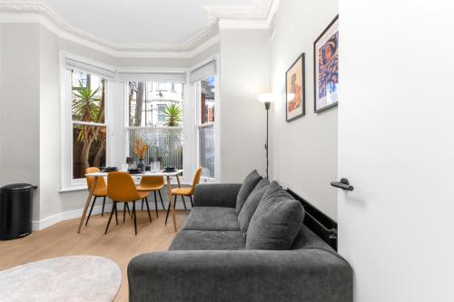 una sala de estar con un sofá y una mesa en Modern 2bed Flat 5 min walk to Brixton & Clapham, en Londres