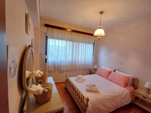 a bedroom with a bed with pink pillows and a window at Mary's vintage house in Athens
