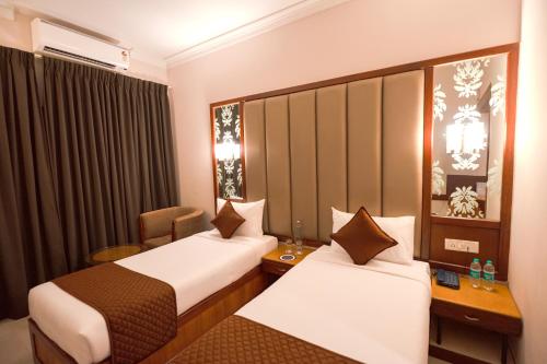 een hotelkamer met twee bedden en een stoel bij U by Z Hotels, Richmond Circle in Bangalore