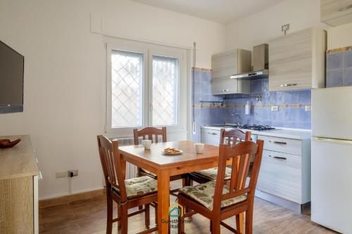 a kitchen with a wooden table and chairs in a kitchen at Dani's House in Isola Sacra