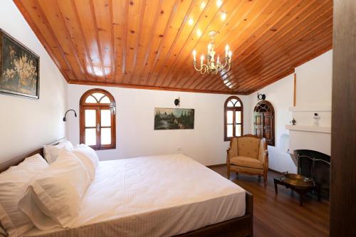 een slaapkamer met een groot wit bed en een kroonluchter bij Villa Starova in Berat