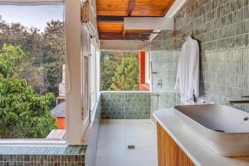 a bathroom with a sink and a window at Unseen Boutique Hotel, Assagao in Assagao