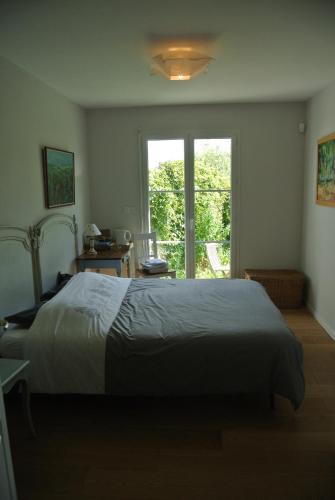 une chambre avec un grand lit et une fenêtre dans l'établissement Homes d opale, Caroline, à Saint-Martin-Boulogne