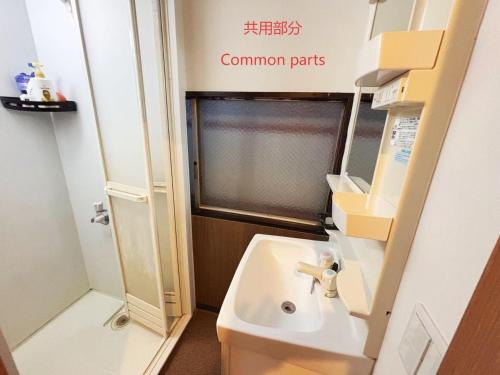 een kleine badkamer met een wastafel en een raam bij 花の郷田端a04 in Tokyo