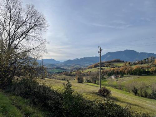 a field with a telephone pole and mountains in the background at Casavacanzebrunella in Sassoferrato