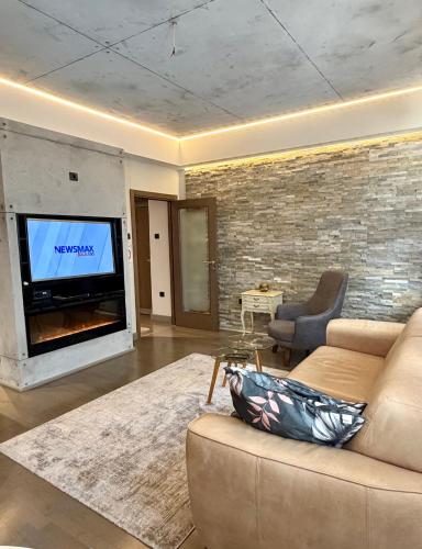 a living room with a couch and a flat screen tv at smgold lux apartman in Podgorica