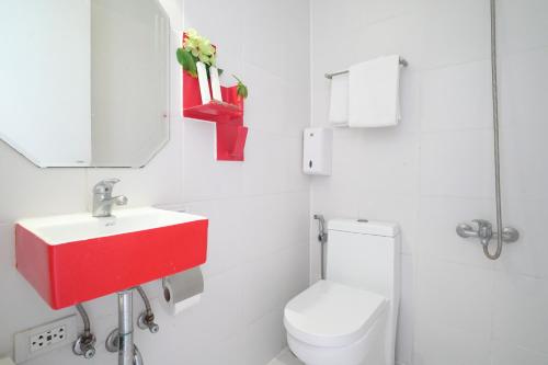 Un baño con inodoro, lavabo y espejo. en La Bella Boutique Hotel, en Tagaytay