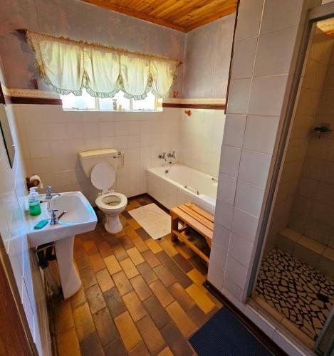 a bathroom with a toilet and a tub and a sink at Home with The Hoffs in Smithfield