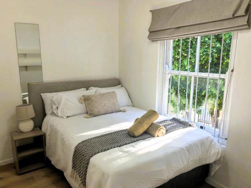 a bedroom with a large bed with a window at Offbeat off Dorp in Stellenbosch
