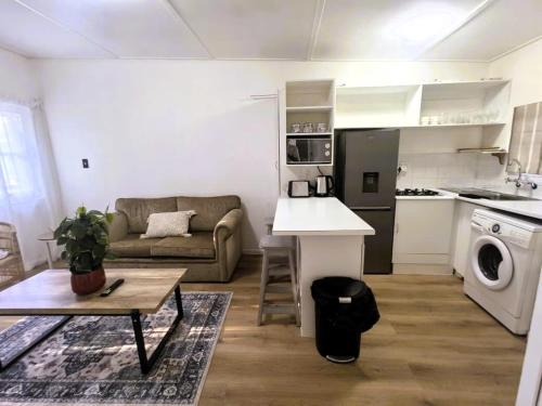 a small living room with a couch and a kitchen at Offbeat off Dorp in Stellenbosch
