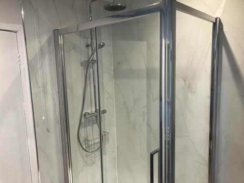 a shower with a glass door in a bathroom at Marsh Garth in Grizebeck